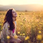 Une femme dans les champs au couché du soleil qui se reconnecter à sa respiration et la nature